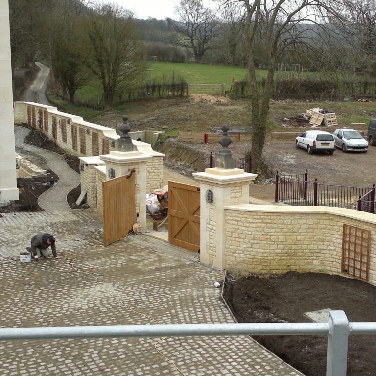 Cotswold stone walls and gate piers. Reclaimed York Stone finials